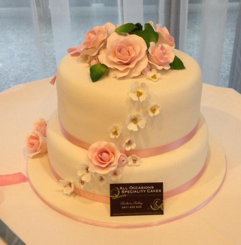 Fondant 2 tier with pink satin ribbon and pink and white sugar flowers Wedding Cake.