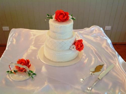 Fondant 3 tier Wedding Cake with large red sugar roses, sugar pearls, lace and quilting. 