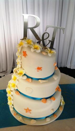 Fondant 3 tier "Onky Wonky" beach themed Wedding Cake Artificial frangipanis. Edible sugar shell decorations.