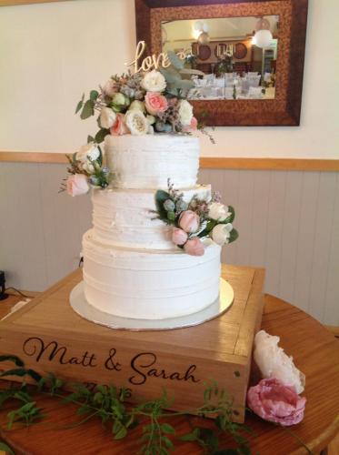 Buttercream 3 tier wedding cake with fresh flowers.